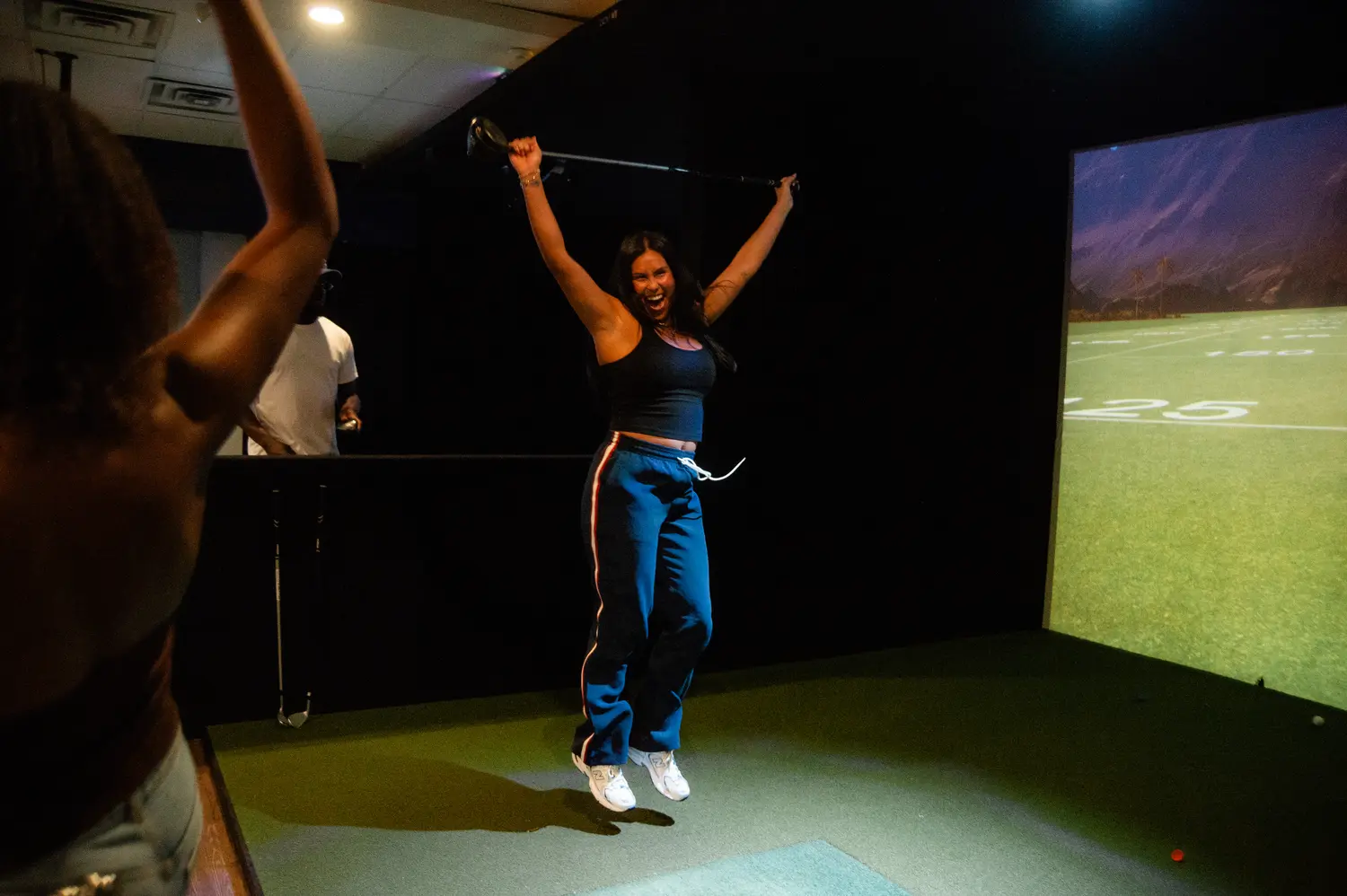 A golfer celebrating with both arms raised at Fairways & Friends